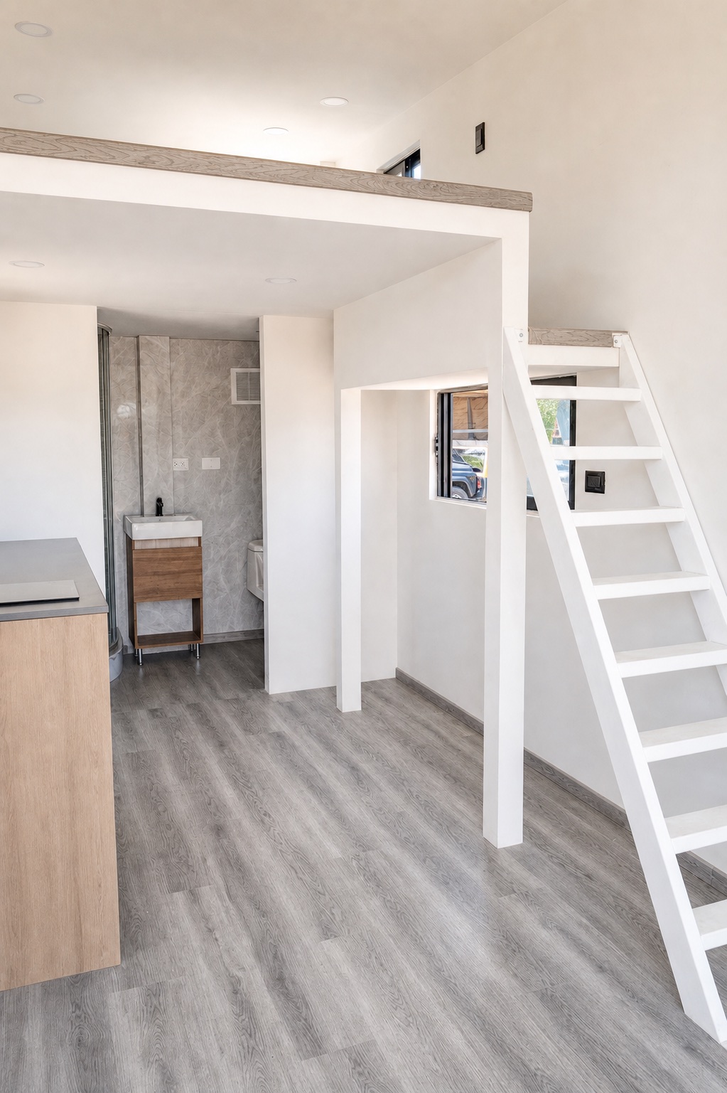 Unstaged Rise20 interior showing the loft, ladder, kitchen edge, and bathroom
