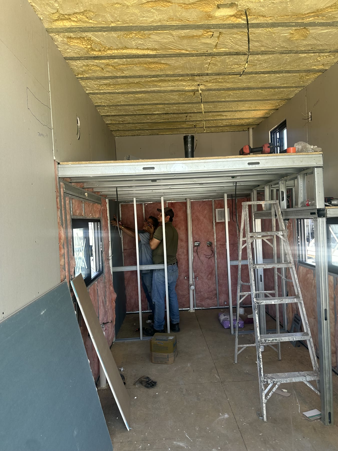 Craftspeople installing interior wall board below the Rise20 loft